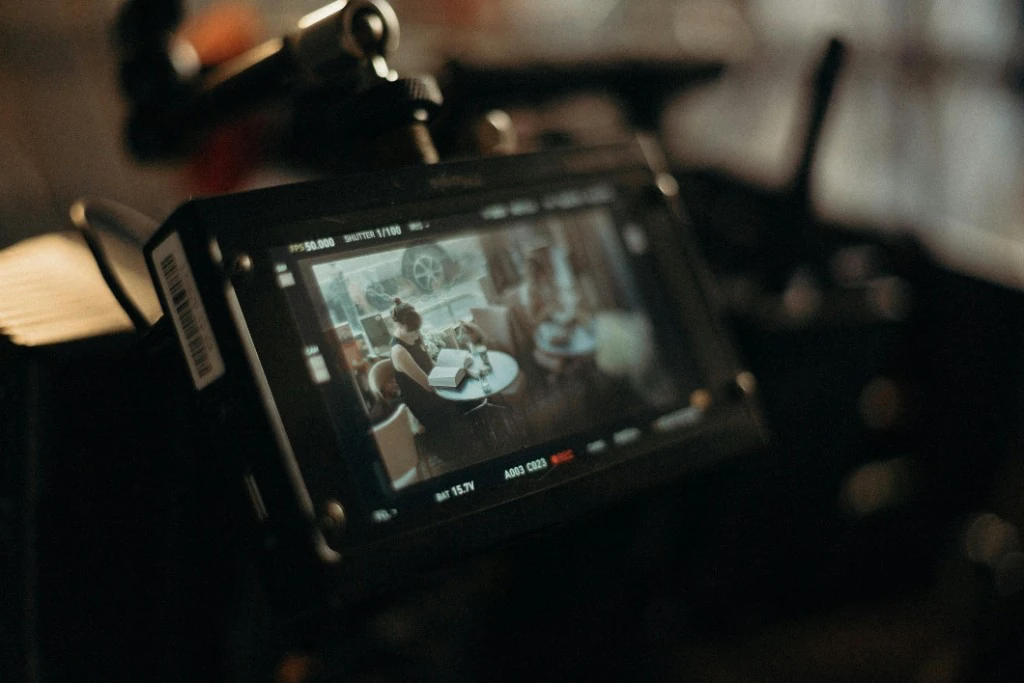 Behind the scenes on a film set — clapperboard and camera crew under red lighting