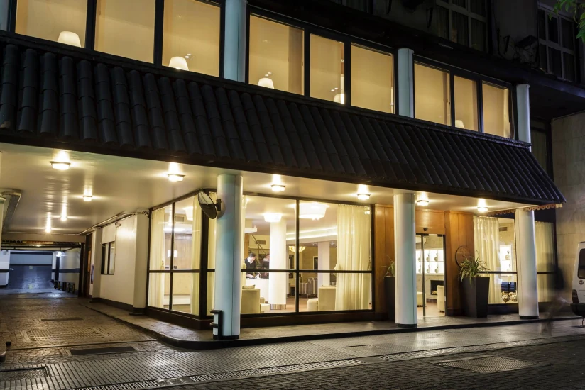 Hotel Facón Grande lobby — glass staircase, wood paneling, and lounge seating