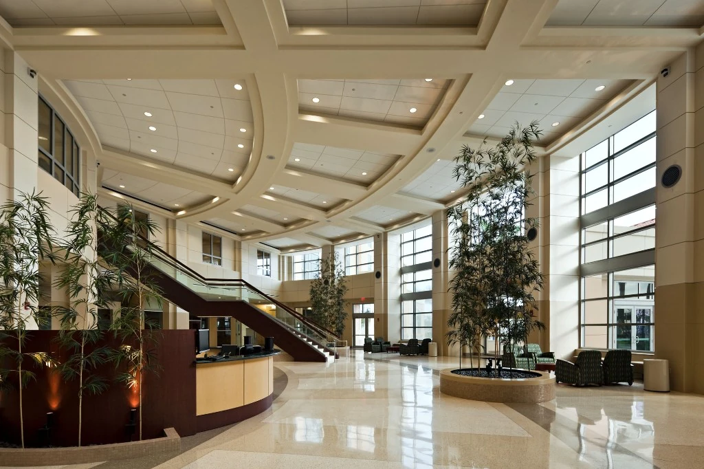 West Kendall Baptist Hospital — bright atrium lobby with reception desk and grand staircase