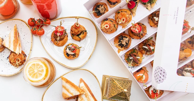 Yamanote Atelier catering spread — savory pastries, toasts, juices, and Japanese Bakery branded box